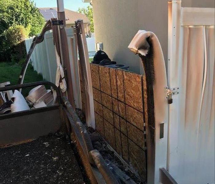 Fence outside of a home that caught on fire shows only minimal damage. 