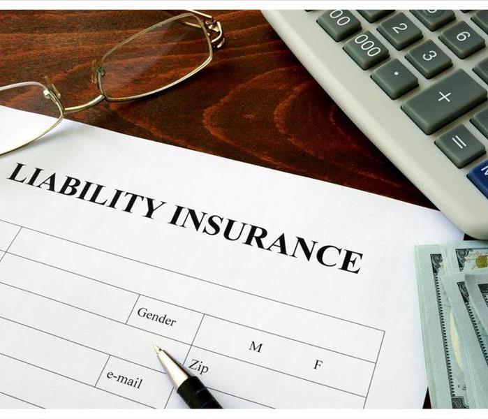 Liability insurance form and dollars on the table.