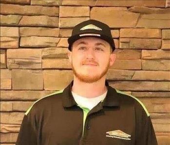 SERVPRO employee in front of brick wall